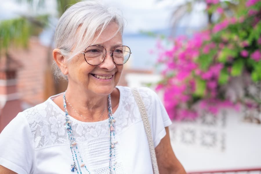 Mujer mayor sonriendo en la calle un día soleado