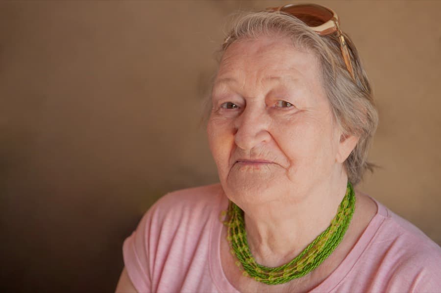 Retrato de una mujer mayor con collar verde